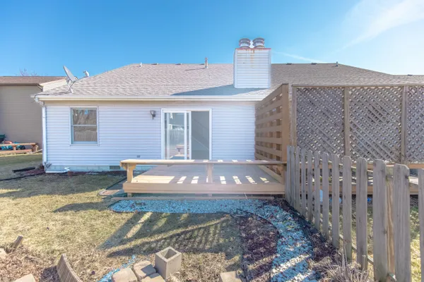 a view of a house with a small yard and wooden fence