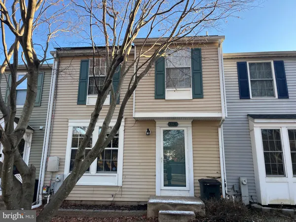 a front view of a house with a tree