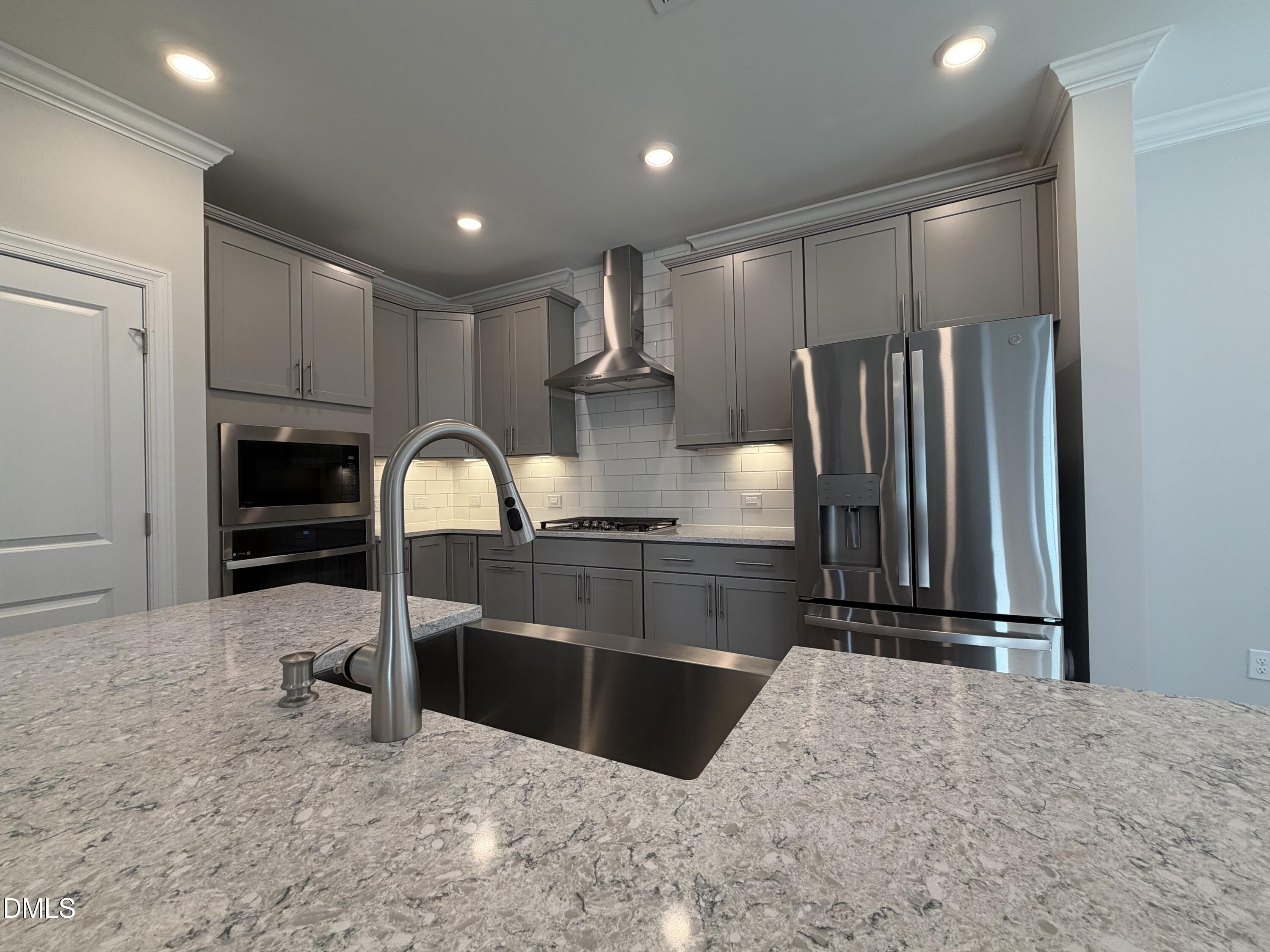 1100 Red Roses Avenue Durham, NC 27703 - Photo 6 of 51 a kitchen with stainless steel appliances kitchen island granite countertop a refrigerator and a sink