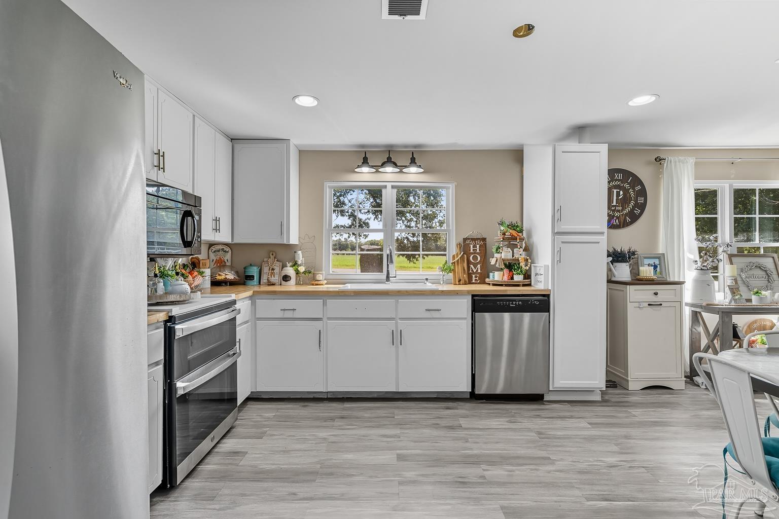 2436 Renfroe Road Pace, FL 32571 - Photo 15 of 45 a kitchen with white cabinets and window
