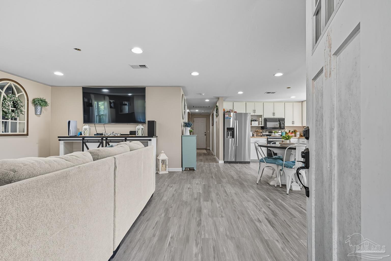 2436 Renfroe Road Pace, FL 32571 - Photo 2 of 45 a kitchen with stainless steel appliances kitchen island granite countertop a refrigerator oven a sink a dining table and chairs with wooden floor