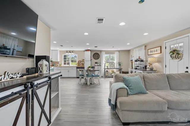 a living room with furniture and wooden floor