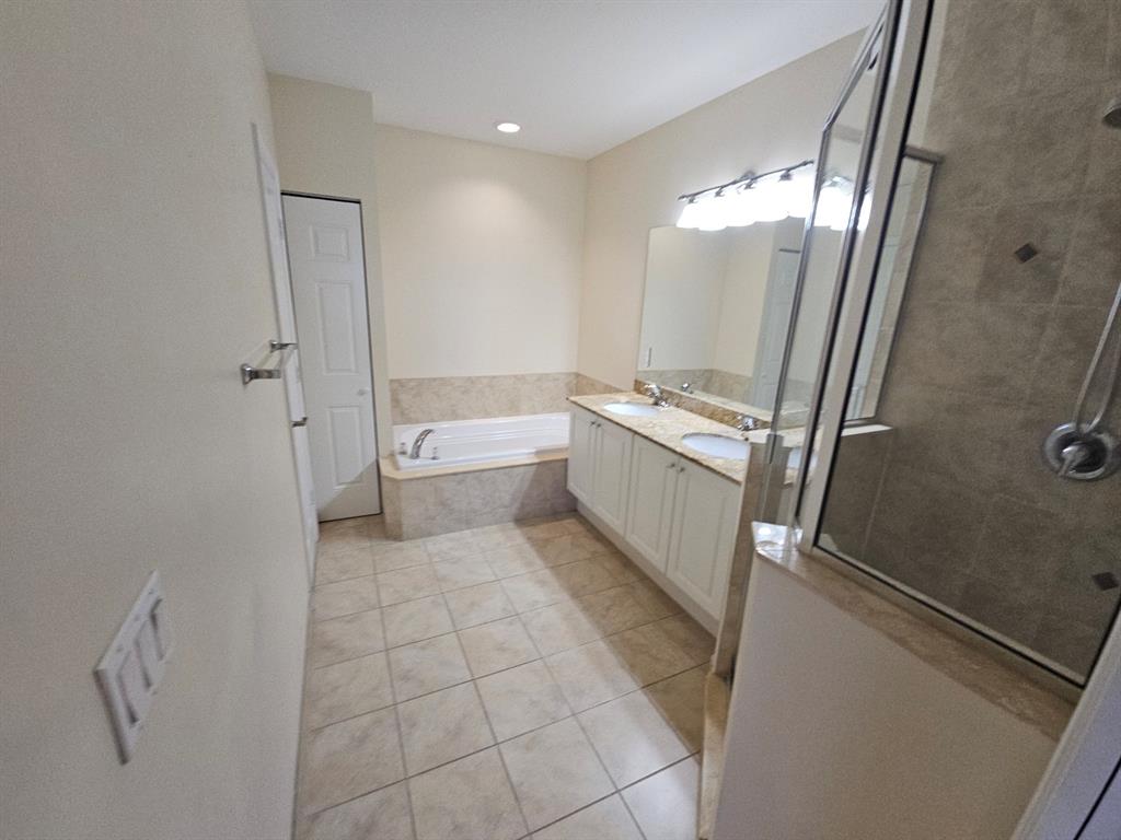 6185 Laurel Lane, Unit B Tamarac, FL 33319 - Photo 7 of 12 a bathroom with a tub sink and mirror