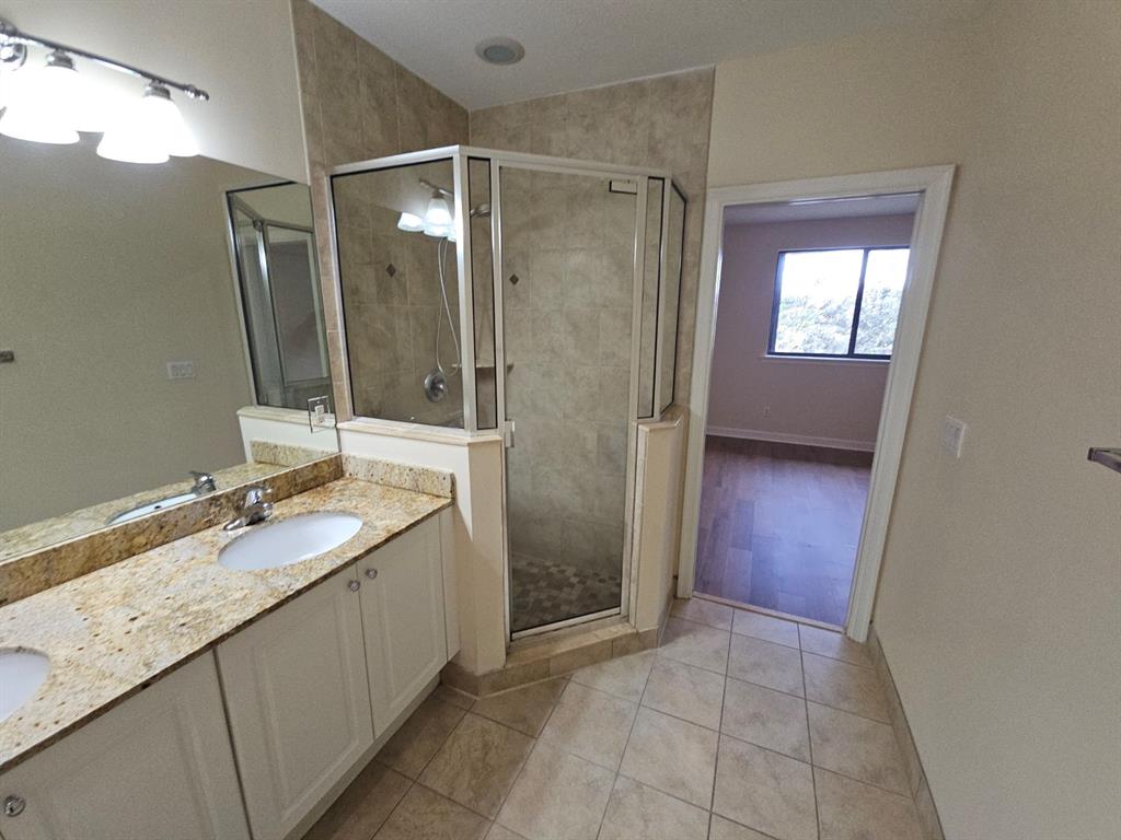 6185 Laurel Lane, Unit B Tamarac, FL 33319 - Photo 8 of 12 a bathroom with a granite countertop sink mirror and shower
