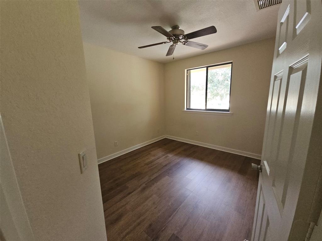 6185 Laurel Lane, Unit B Tamarac, FL 33319 - Photo 9 of 12 an empty room with wooden floor fan and windows