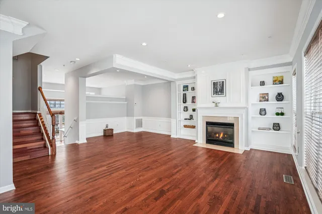 a view of empty room with wooden floor and fireplace