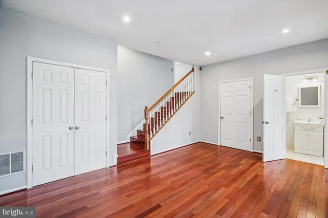 a view of empty room with wooden floor and fan