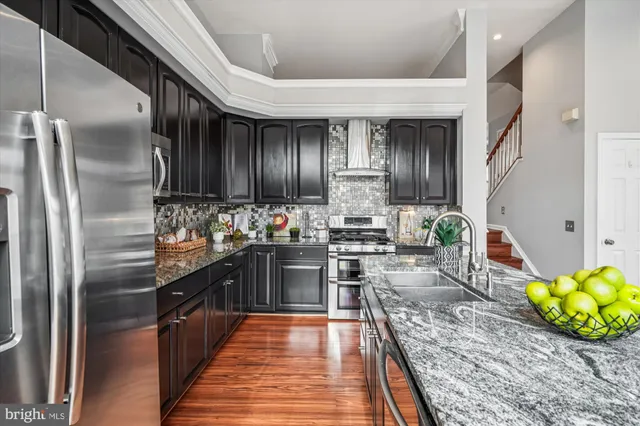 a kitchen with stainless steel appliances granite countertop a stove a sink and a refrigerator