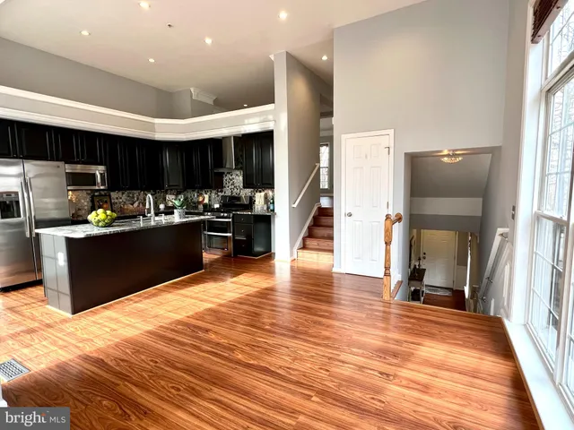 a kitchen with stainless steel appliances kitchen island granite countertop a refrigerator and a stove top oven