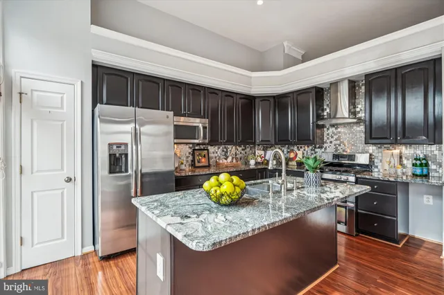 a kitchen with granite countertop kitchen island wooden cabinets and stainless steel appliances