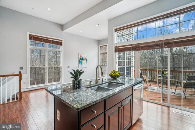 a kitchen with granite countertop a stove a sink and a wooden cabinets
