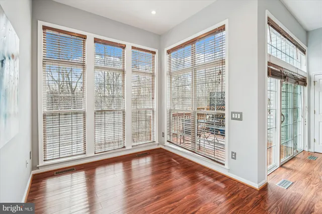 a view of empty room with wooden floor and floor to ceiling window