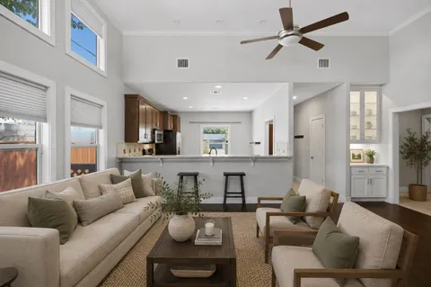 a living room with furniture and a view of kitchen