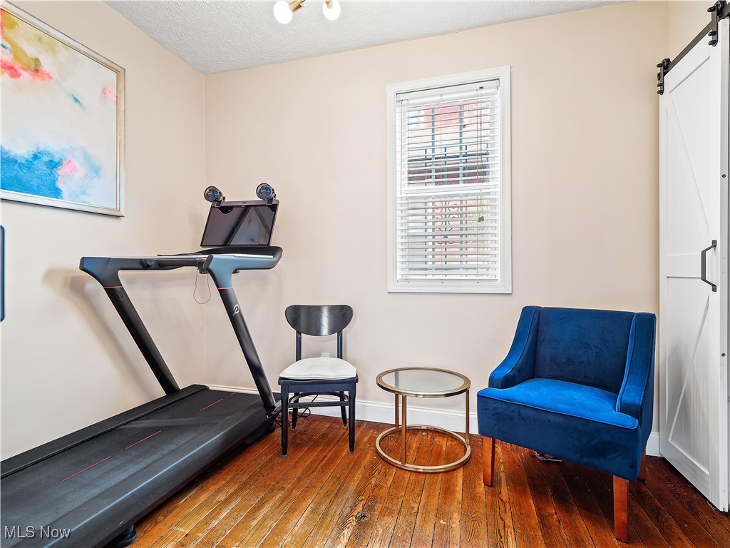 1727 Randall Road Cleveland, OH 44113 - Photo 23 of 40 Exercise room with a barn door and hardwood / wood-style flooring