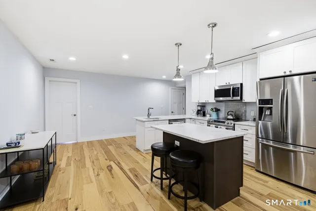 a kitchen with kitchen island a sink appliances and cabinets