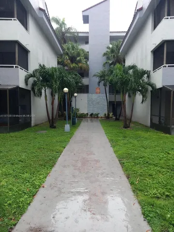 a front view of a house with a yard and potted plants