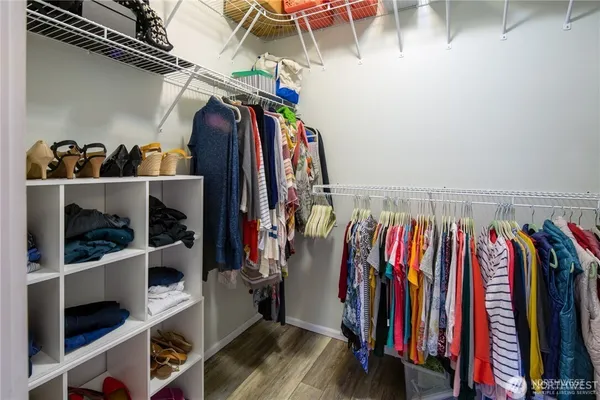 a view of walk in closet with clothes and shoes