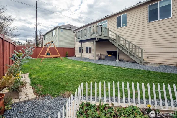 a view of a house with a yard and deck