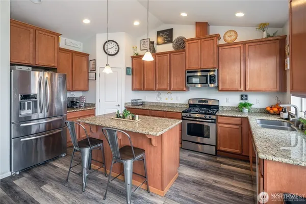 a kitchen with granite countertop stainless steel appliances and wooden cabinets