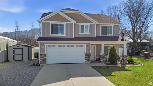 1084 South 740 East Logan, UT 84321 - Photo 1 of 23 Craftsman-style home featuring stone siding, a porch, driveway, and a garage