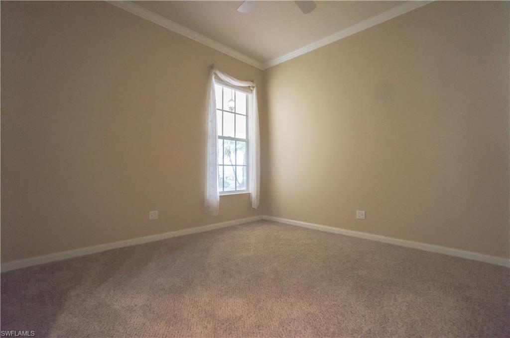 5120 Inagua Way Naples, FL 34119 - Photo 19 of 35 an empty room with windows and chandelier fan