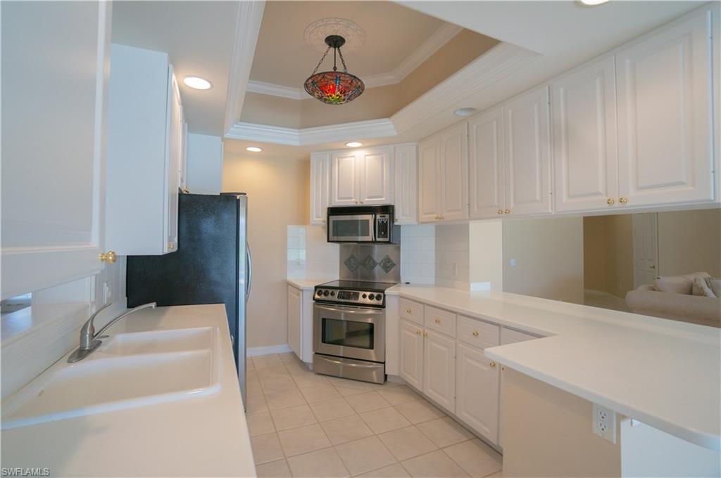 5120 Inagua Way Naples, FL 34119 - Photo 7 of 35 a kitchen with a sink a microwave a stove and refrigerator