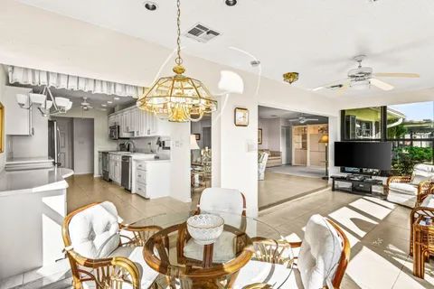 a living room with furniture a chandelier and a flat screen tv