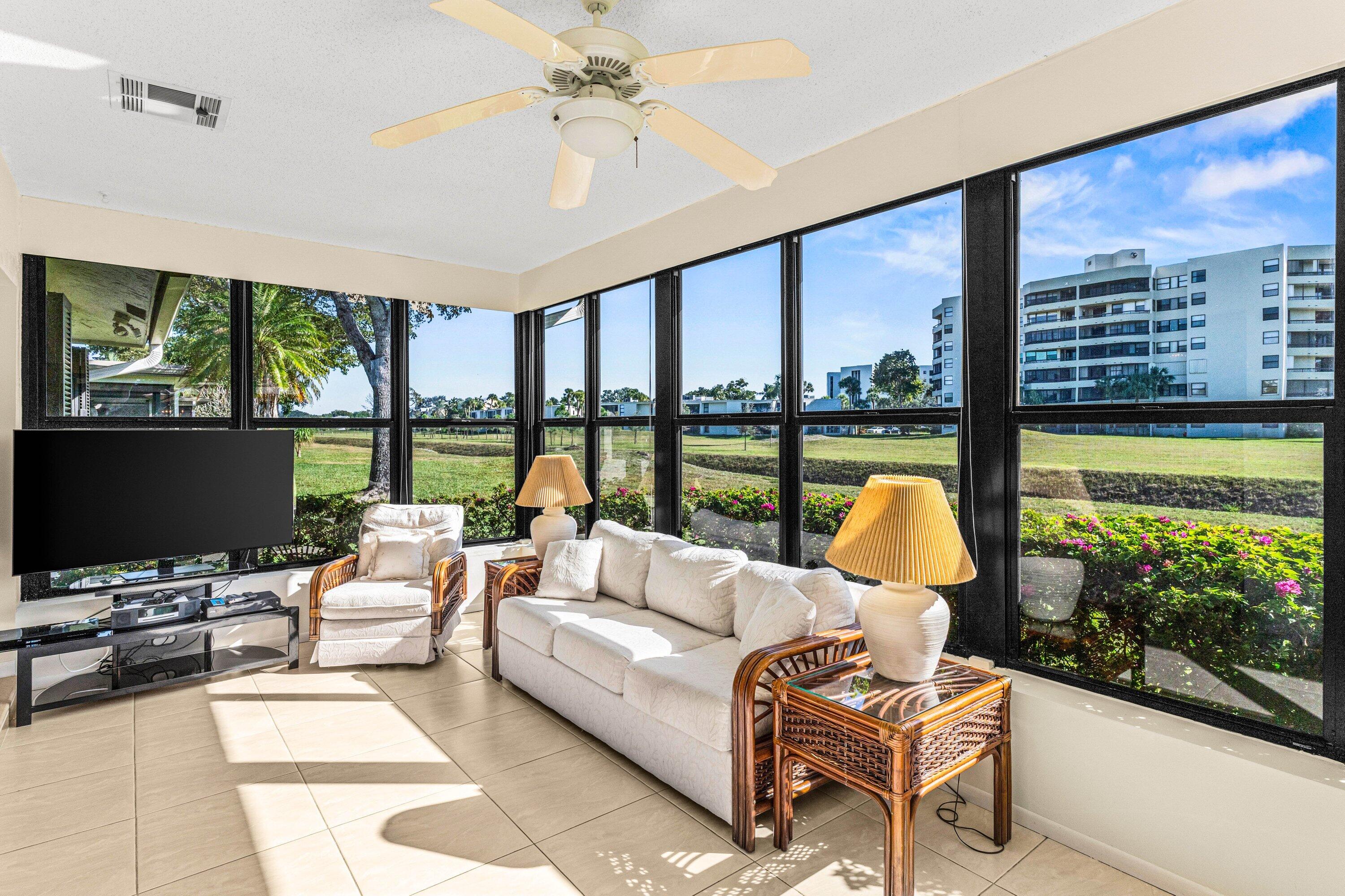 6426 Casabella Lane Boca Raton, FL 33433 - Photo 29 of 42 a living room with furniture tv and a floor to ceiling window