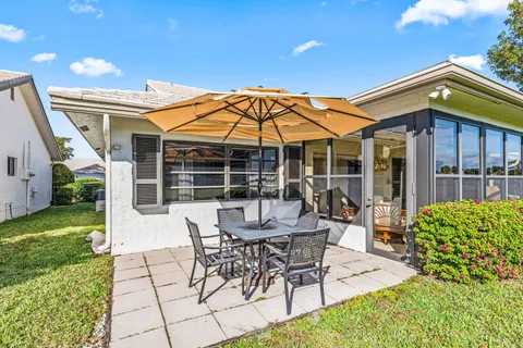 a view of a house with backyard sitting area and garden