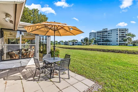 a view of a patio with a table and chairs under an umbrella