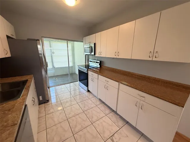 a kitchen with stainless steel appliances granite countertop a refrigerator sink and cabinets