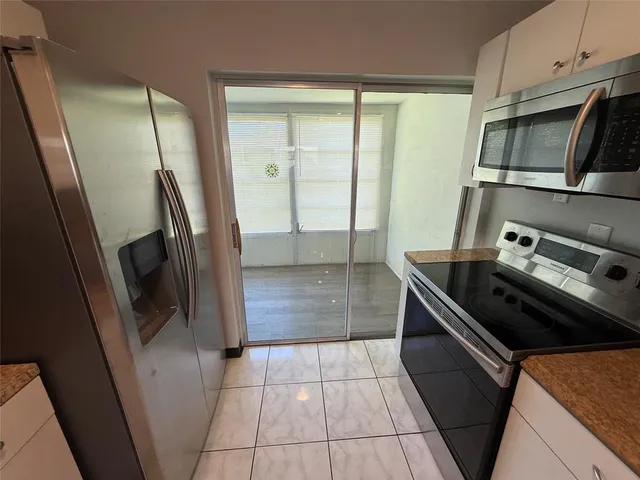 a kitchen with a refrigerator a stove top oven and a counter top space