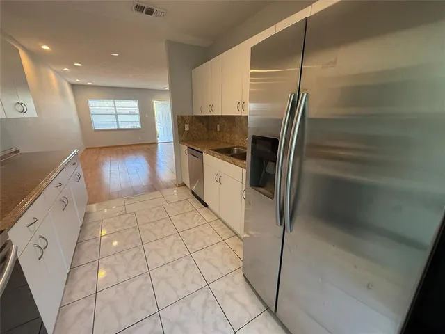 a kitchen with stainless steel appliances granite countertop a refrigerator and a sink