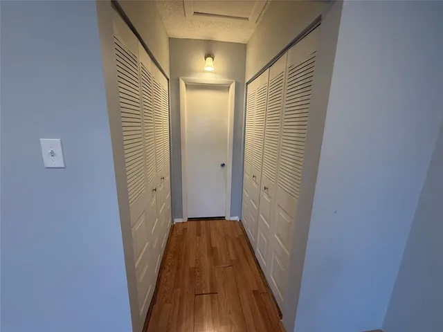 a view of a hallway with wooden floor