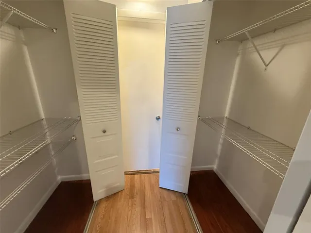 a view of walk in closet with wooden floor