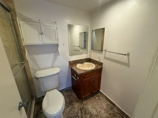 a bathroom with a sink toilet and mirror
