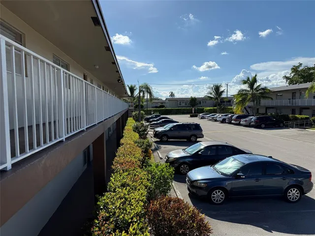a view of swimming pool with a yard and palm trees