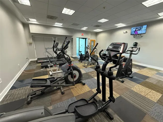 a gym room with lots of chairs and wooden floor