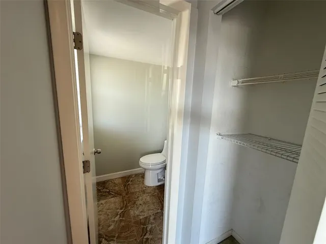 a bathroom with a granite countertop toilet and a shower