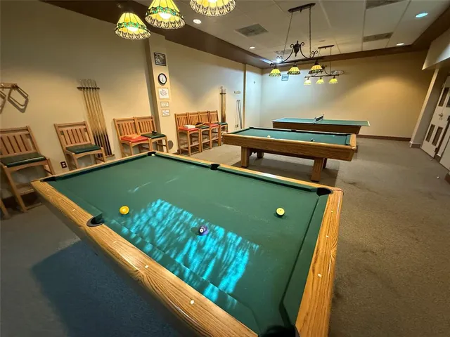 a room with pool table and windows