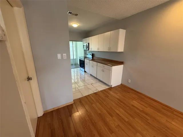 a kitchen with granite countertop white cabinets and wooden floor