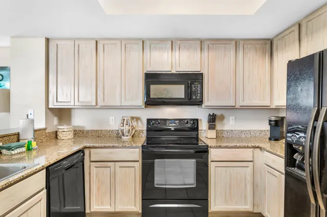a kitchen with stainless steel appliances granite countertop white cabinets sink and a granite counter top