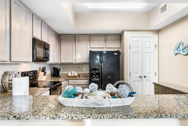 a kitchen with a refrigerator and a stove top oven