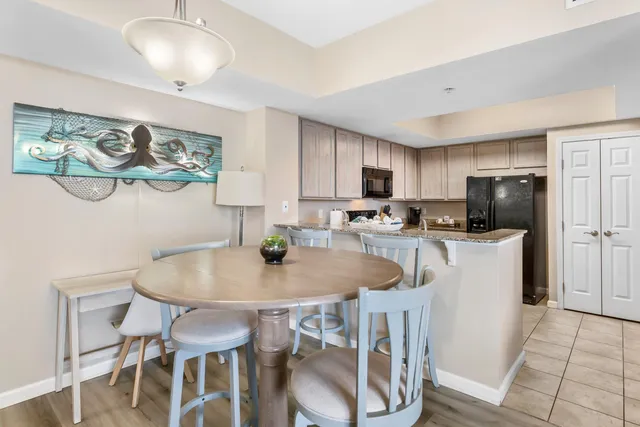a kitchen with a dining table chairs and refrigerator