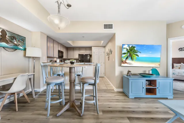 a kitchen with stainless steel appliances kitchen island granite countertop a table chairs and a refrigerator
