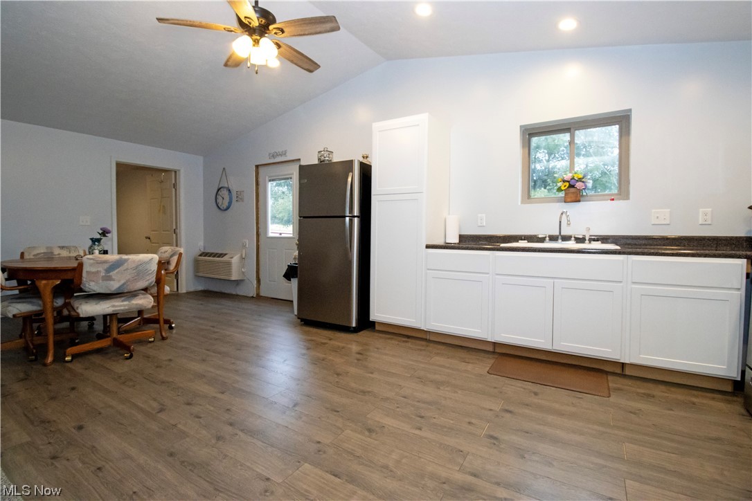 8084 Millbrook Road Shreve, OH 44676 - Photo 25 of 35 Kitchen featuring sink, stainless steel refrigerator, light wood-type flooring, vaulted ceiling, and white cabinets