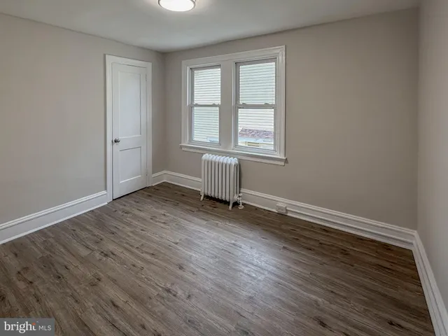 a view of a hallway with wooden floor and entryway
