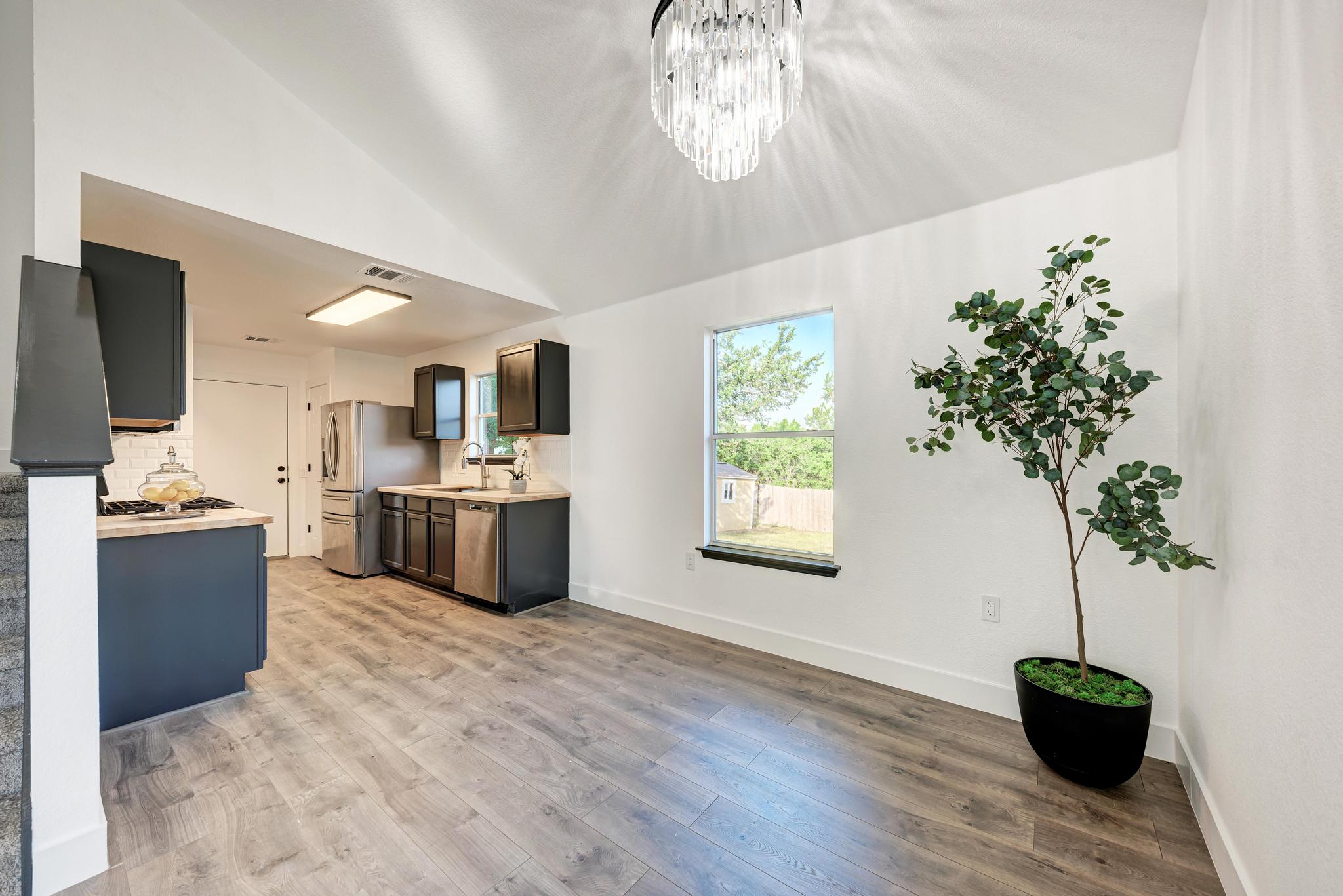 18108 Belfry Pass Manor, TX 78653 - Photo 16 of 40 a large kitchen with a potted plant a sink and a stove