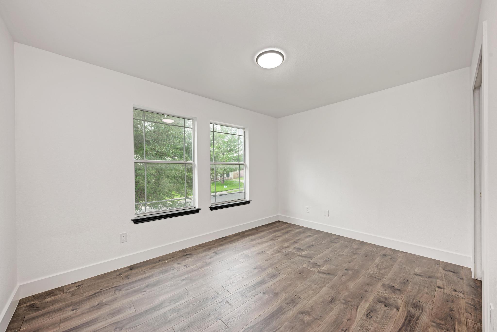 18108 Belfry Pass Manor, TX 78653 - Photo 29 of 40 an empty room with wooden floor and windows