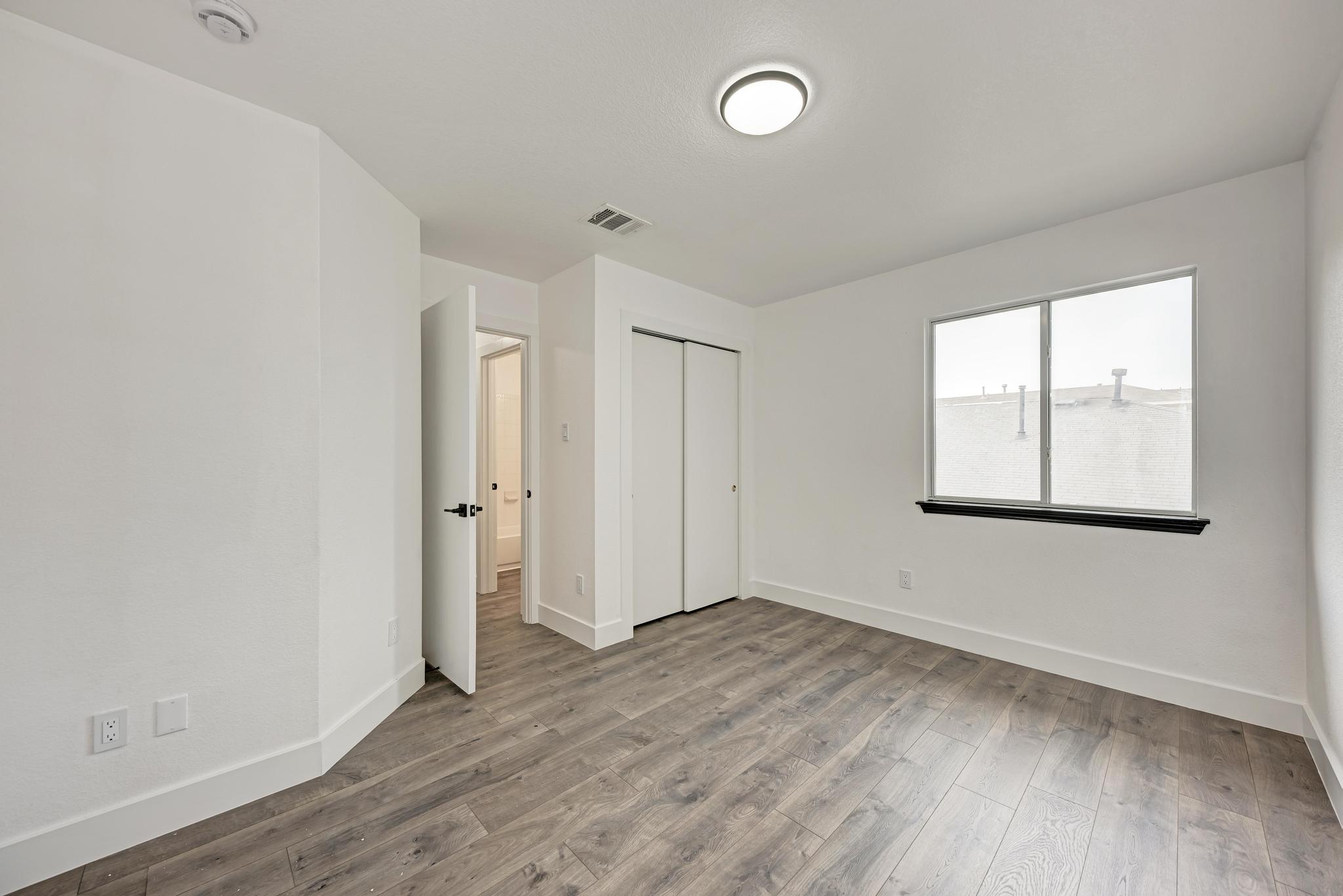 18108 Belfry Pass Manor, TX 78653 - Photo 32 of 40 an empty room with wooden floor and windows